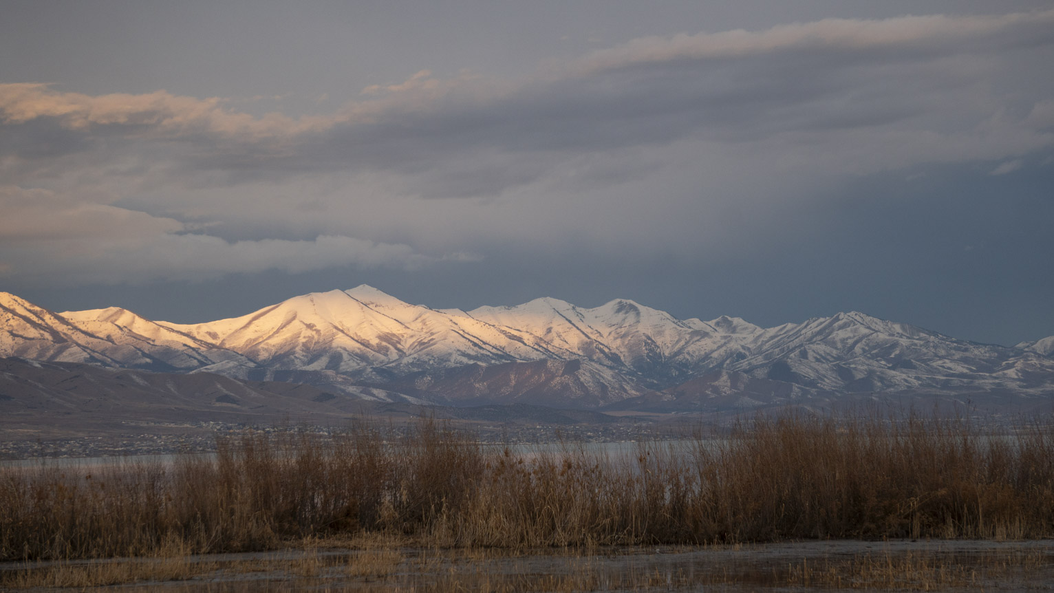 The mountains catch some light on a cloudy day at the lake